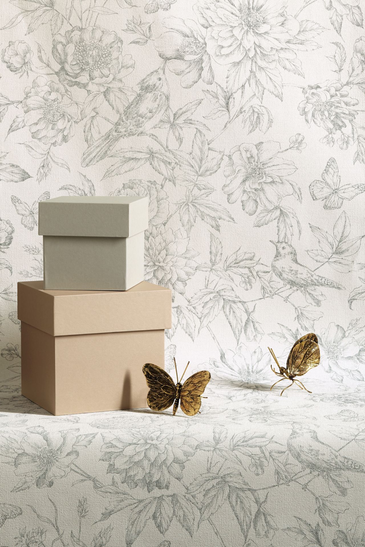 Wohntrends - Kartonboxen und Schmetterlinge vor einer geblümten Tapete von Rasch
